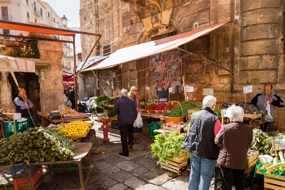 Klanten keuren verse waren op een markt in Palermo