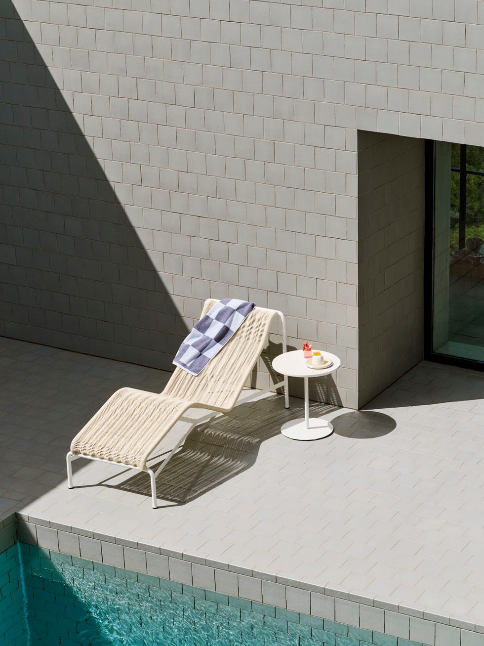 a sunlounger next to a pool