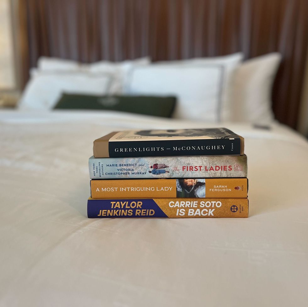a stack of books on a bed