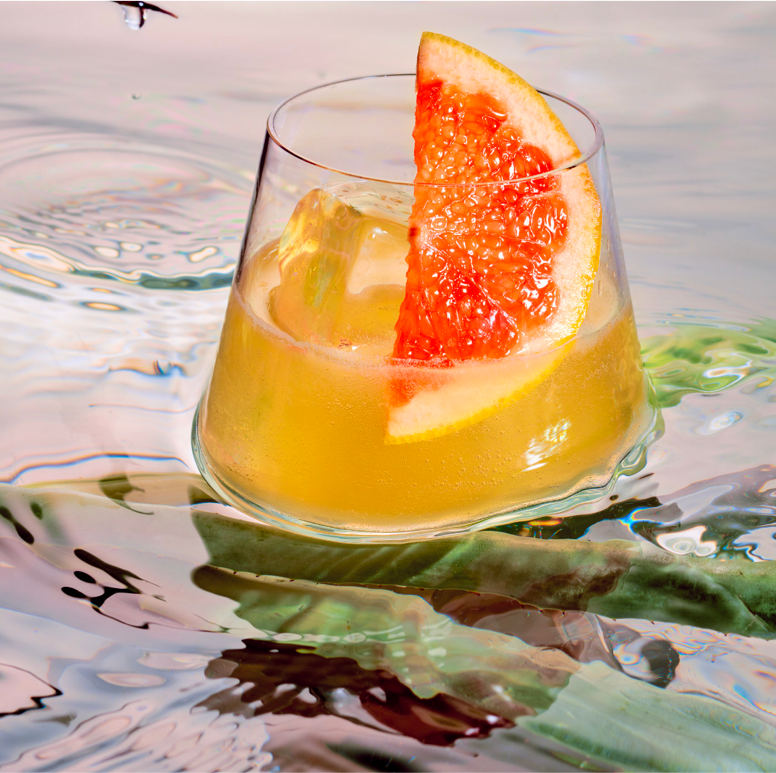 orange cocktail floating in water