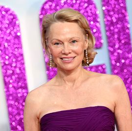 pamela anderson smiles wearing purple dress