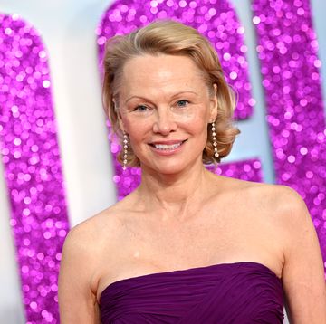 pamela anderson smiles wearing purple dress