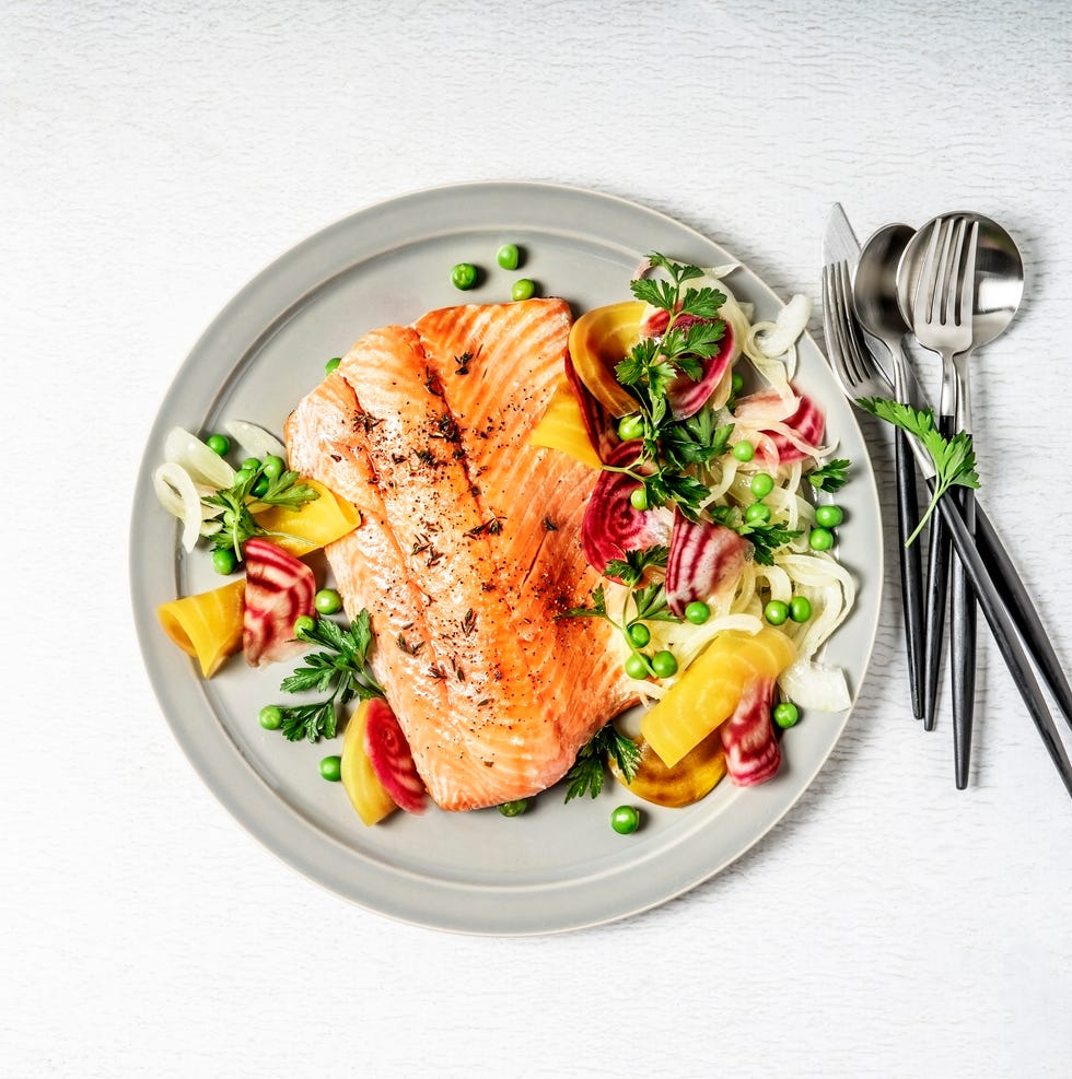 pan fried salmon with vegetables on white background