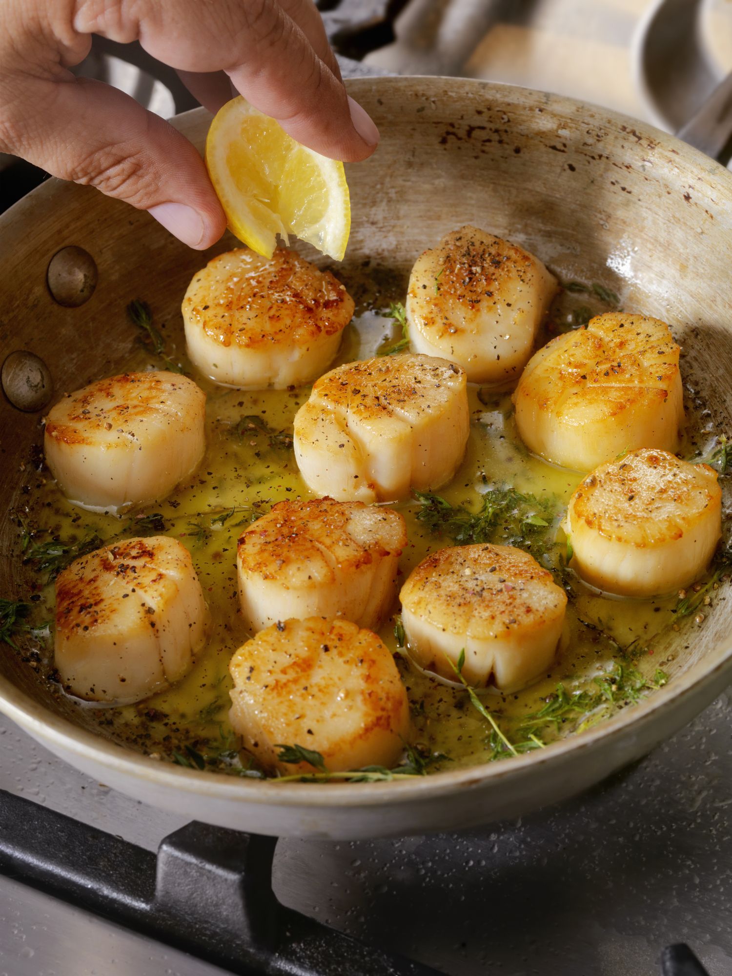 https://hips.hearstapps.com/hmg-prod/images/pan-searing-scallops-in-butter-royalty-free-image-1641398070.jpg