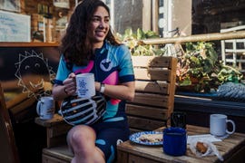 female cyclist eating outside a cafe