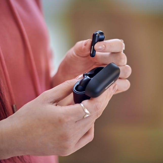 wireless earbuds being held with charging case