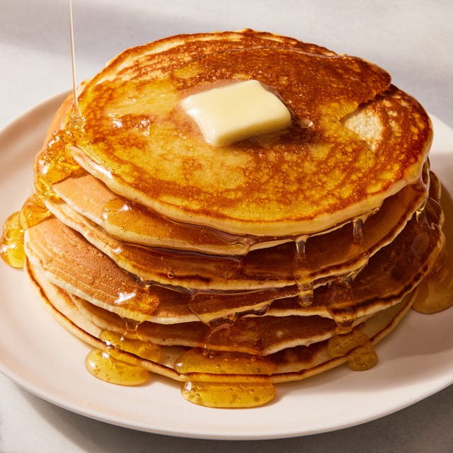 stack of homemade pancakes with a pat of butter and syrup