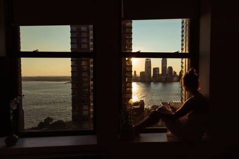 pandemic covid 19 lockdown pensive woman home at the window over new york city manhattan