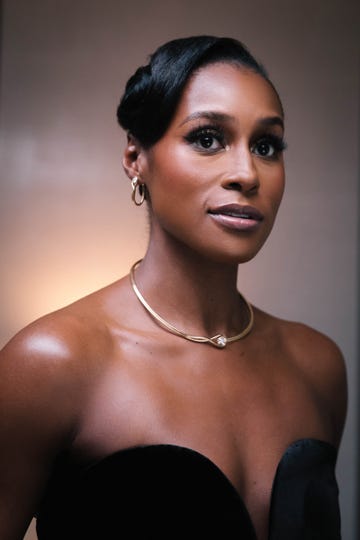 Portrait of a person wearing a black strapless dress and a gold necklace