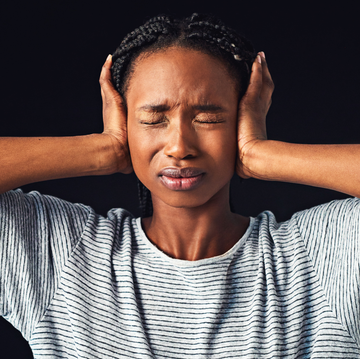 stressed woman with hands on ears