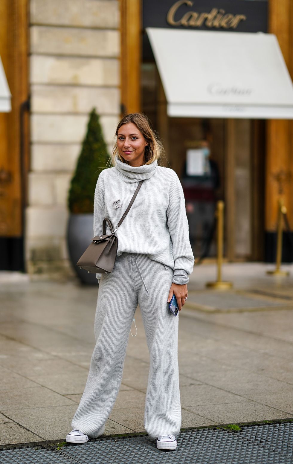 paris, france   september 29 diane perreau wears a gray wool turtleneck pullover, a chanel brooch, a brown leather hermes bag, flared pants, sneakers, during paris fashion week   womenswear spring summer 2021 on september 29, 2020 in paris, france photo by edward berthelotgetty images