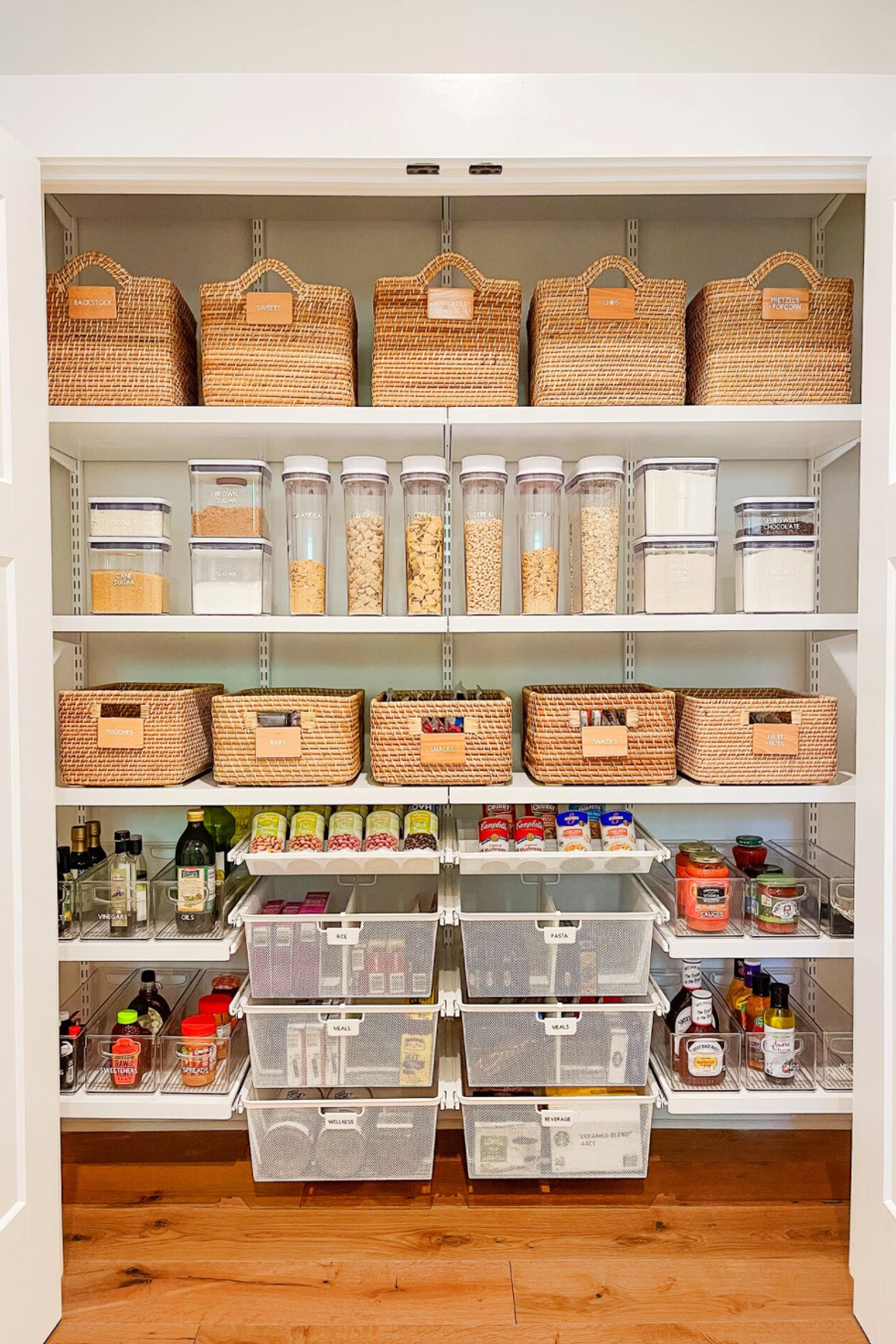 pantry organization ideas, opened pantry closet with containers and baskets of food on white shelves