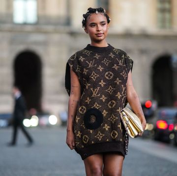 a model wears a louis vuitton sweater dress vest while walking in paris during fashion week