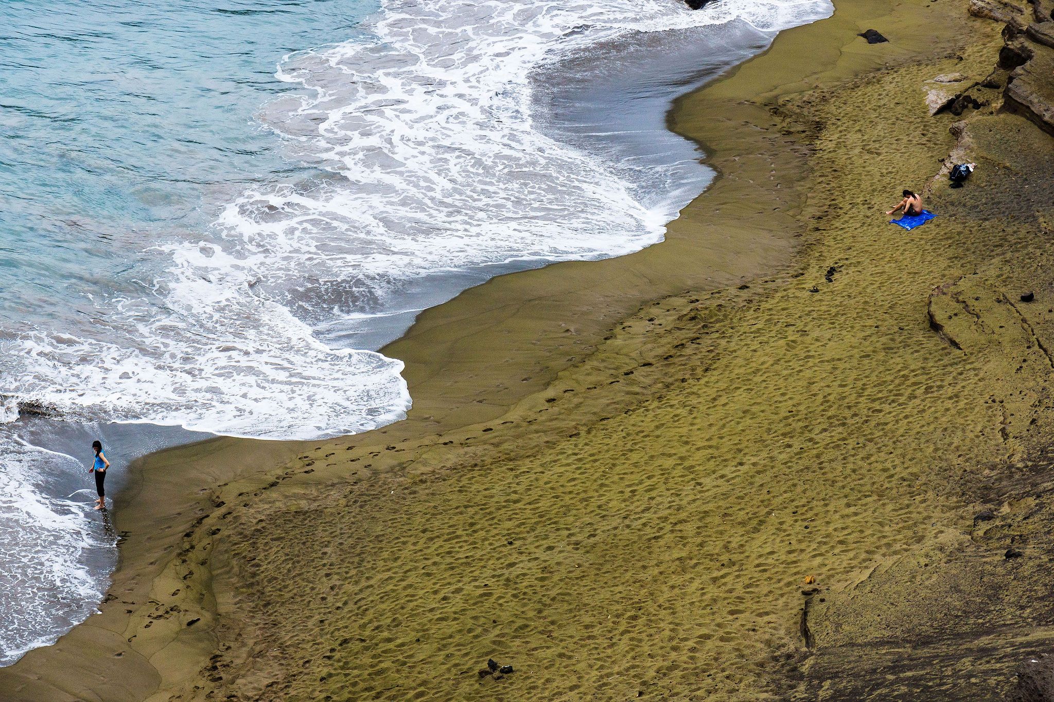 Van aan afstand lijkt het soms op gras maar in werkelijkheid is het het groene zand van Green Sands Beach op het Hawaaanse Big Island