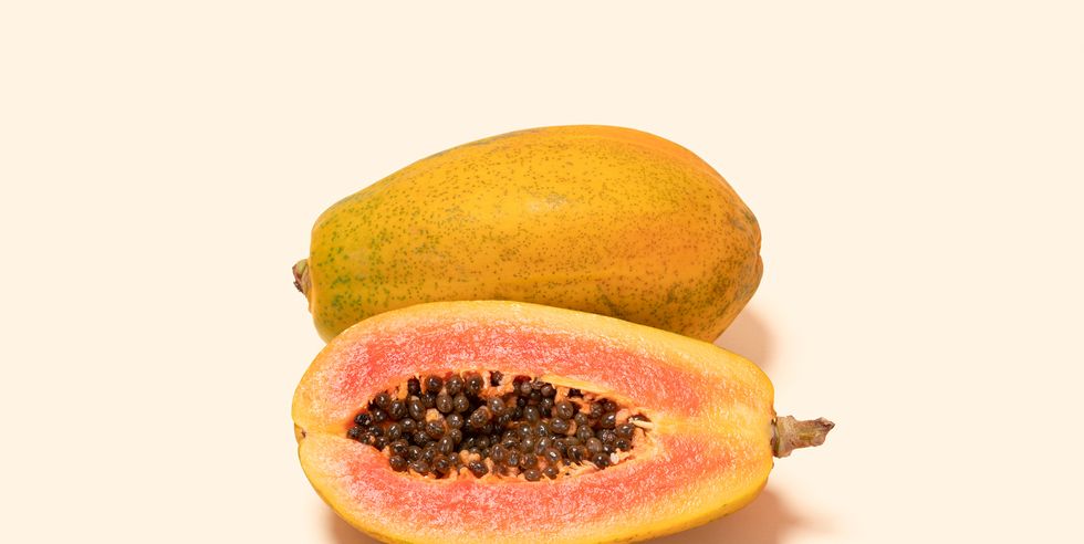 papaya and cross section on colored background