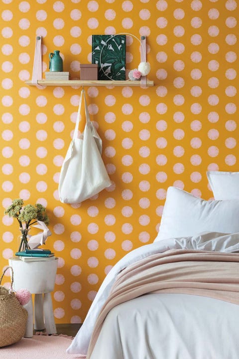 dormitorio con papel pintado amarillo con topos rosa