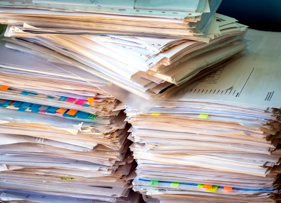 pile of papers and folders on a work table.