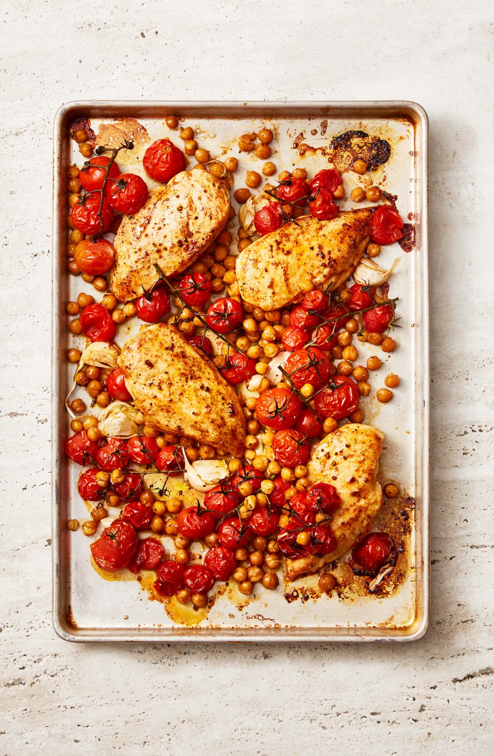 paprika chicken with crispy chickpeas and tomatoes on a sheet pan