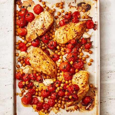 paprika chicken with crispy chickpeas and tomatoes on a sheet tray