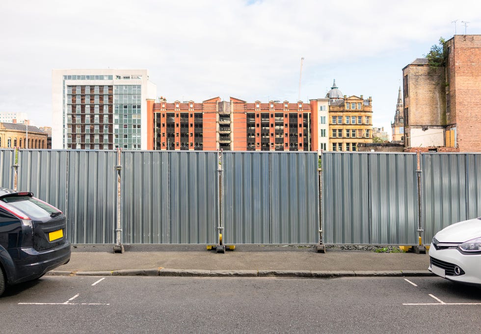 an empty, available car parking space between two cars on a british street