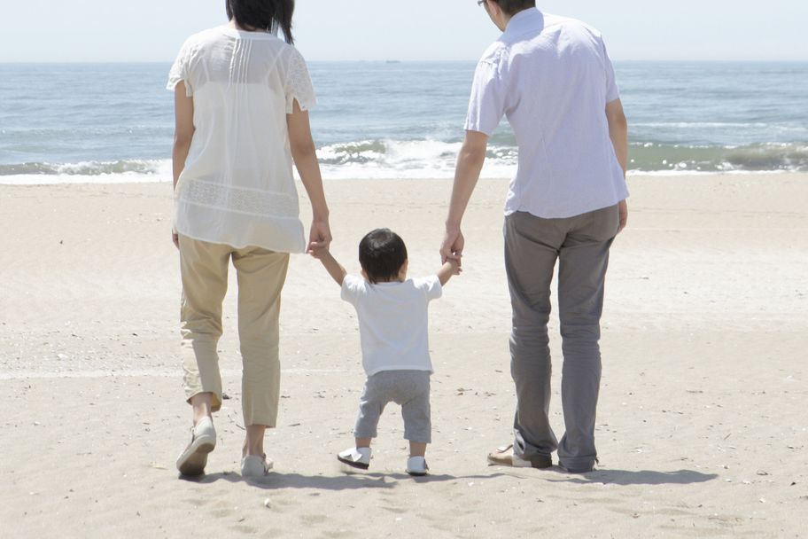 parents and child walking on beach