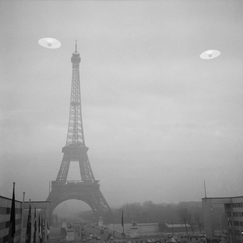 flying saucers over eiffel tower black and white photo