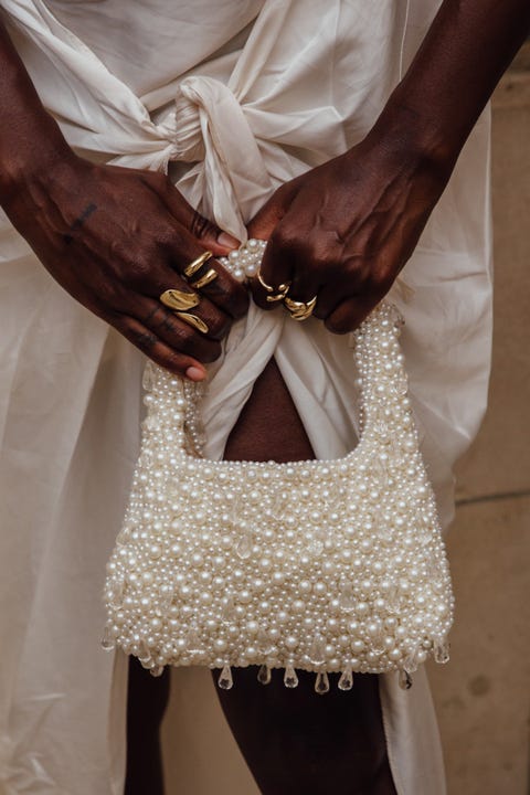 a person wearing a white dress and gold jewelry