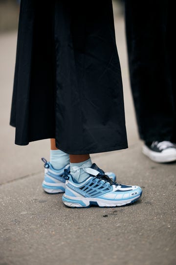 a person's feet wearing blue and white shoes