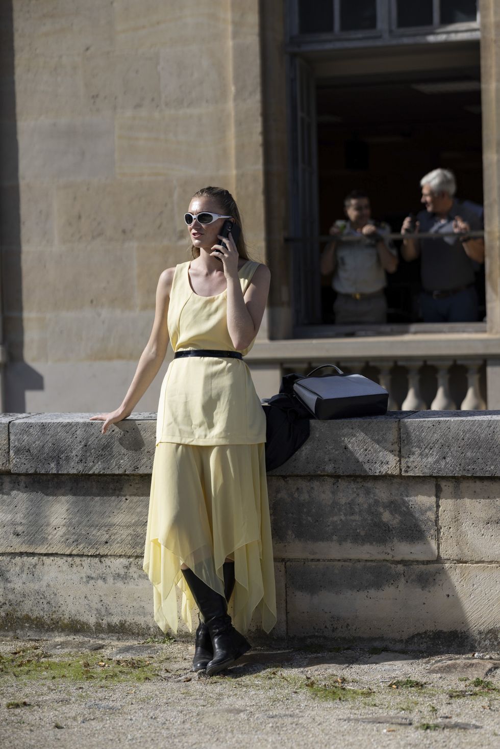 a person in a yellow dress talking on a cell phone
