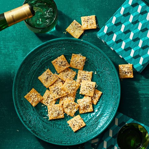 parmesan seeded crackers in a teal ceramic bowl