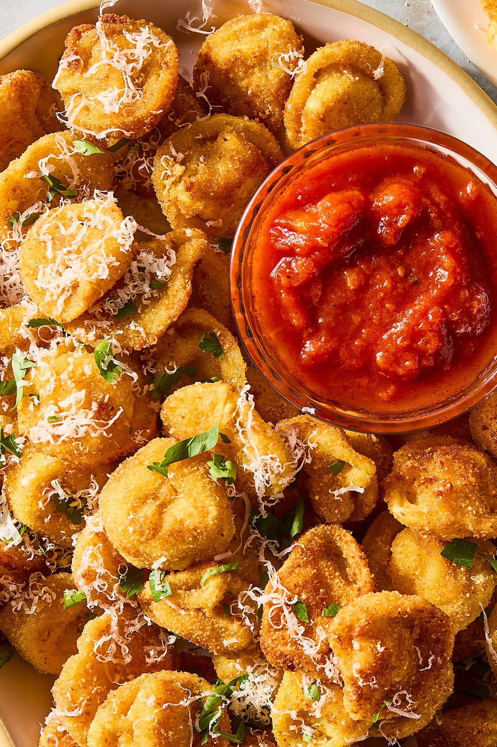 Parmesan Tortellini Bites Deep fried tortellini topped with Parmesan and served with marinara sauce