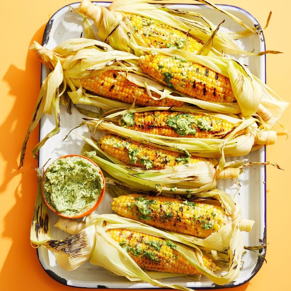 charred corn still in their husks with parmesan parsley butter on the side