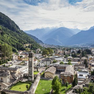 parrocchia di san lorenzo in town by mountain against sky, valchiavenna, chiavenna, province of sondrio, lombardy, italy