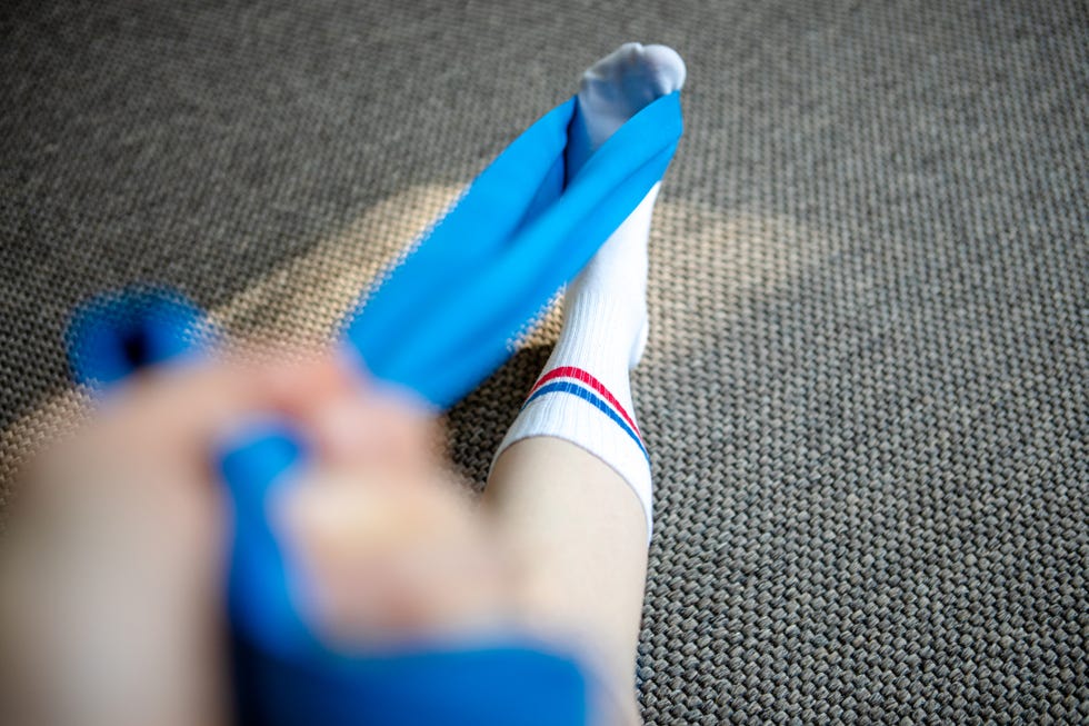 doctor examining womans feet in office