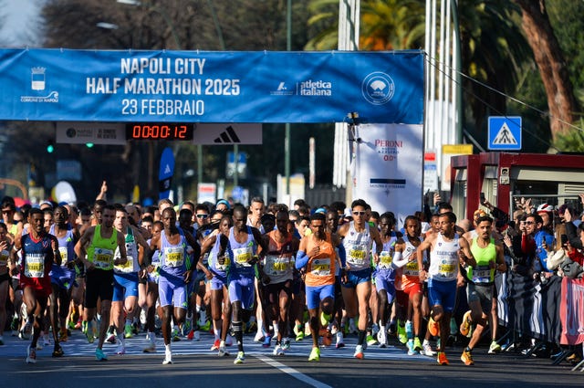 group of runners starting a marathon race under a banner