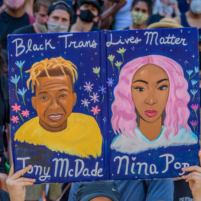 a participant holding a black trans lives matter sign at the