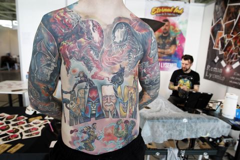a participant is seen showing off his tattooed body during