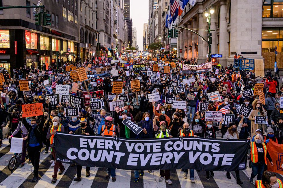 participants holding a banner reading "every vote counts