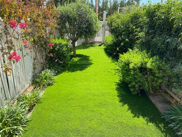 a yard with a fence and bushes