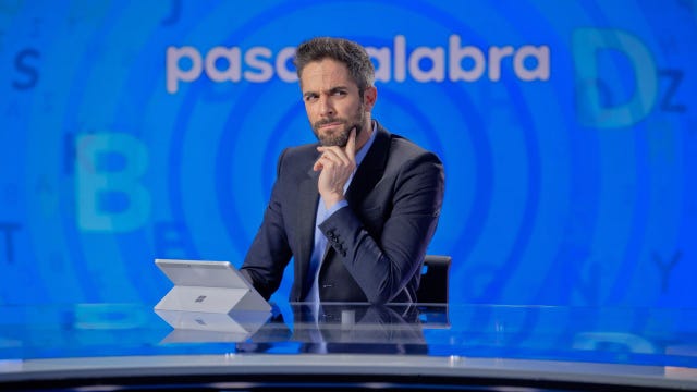 roberto leal sentado en la mesa del plató de pasapalabra