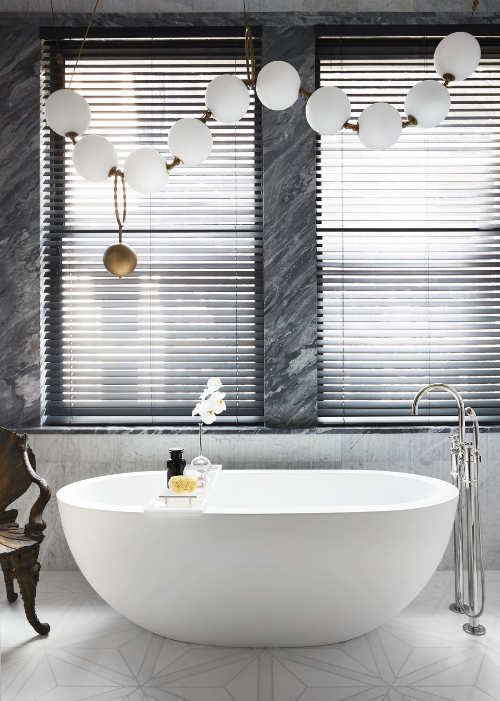a handcrafted pearl like lighting fixture by canadian designer larose guyon dangles over a deep soaking tub