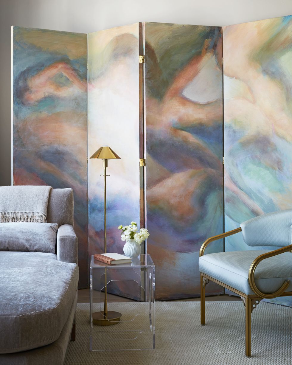 a hand painted screen depicting abstract nudes by artist francis nguyen brings ethereal color to a corner of the living room