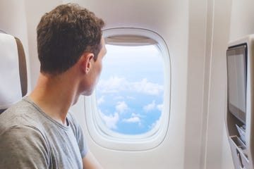 passenger traveler looking at window in airplane, travel by flight