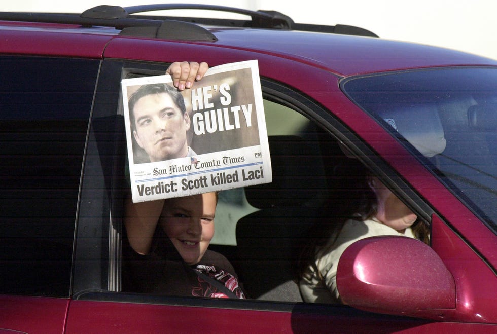 a person holds a newspaper announcing scott peterson was found guilty of murder