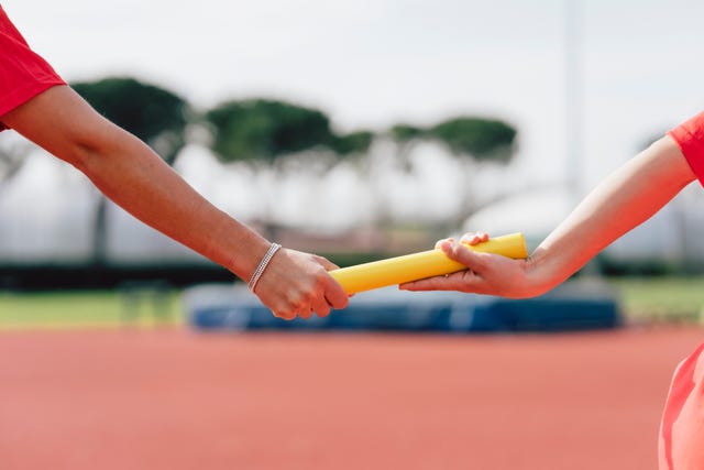 passing the relay baton on the track field