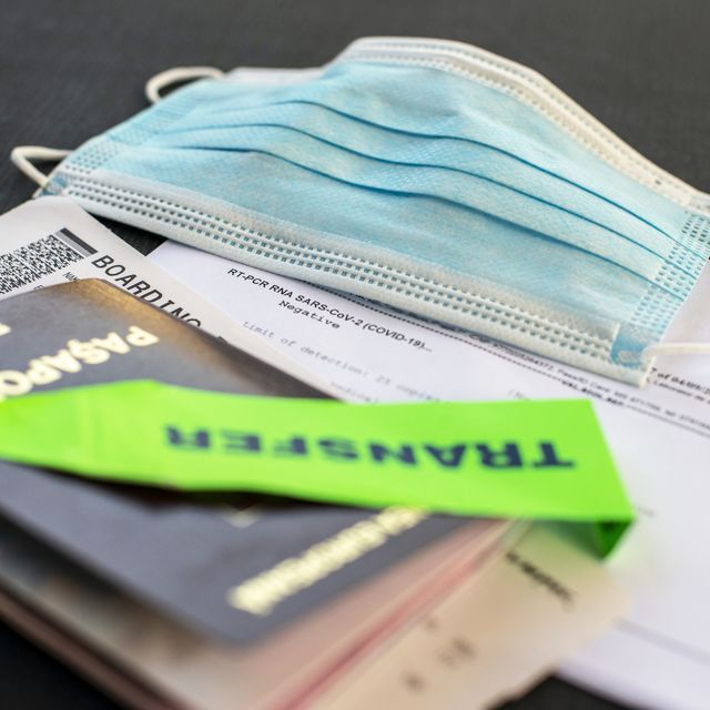 passport, face mask, boarding pass and covid pcr test  at the airport check in desk