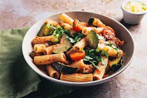 high angle view of rigatoni with zucchini and tomato sauce