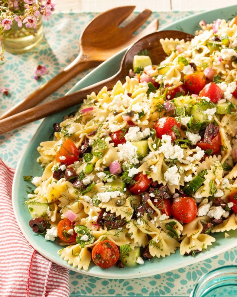 greek pasta salad with wooden spoons