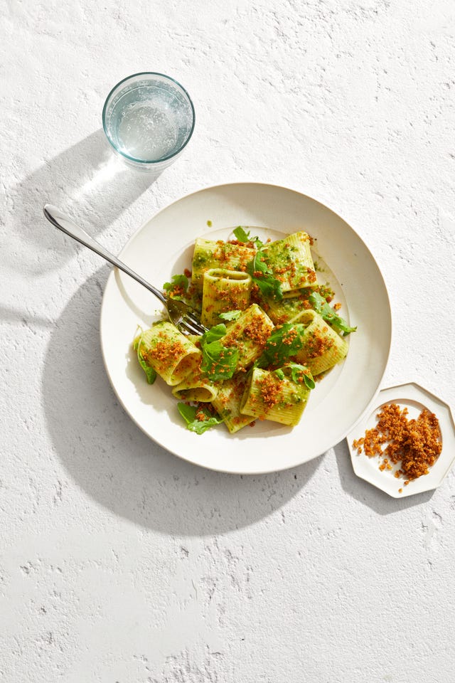 pasta dish with pesto sauce and toasted breadcrumbs on top