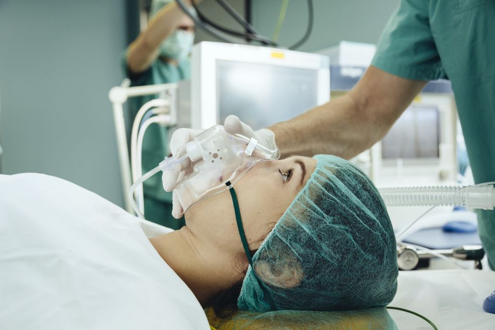 Patient with a respiratory mask on operating table
